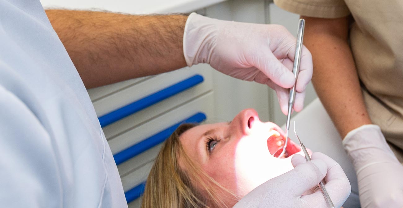 Foto von Zahnarzt Totolici, der eine Patientin behandelt