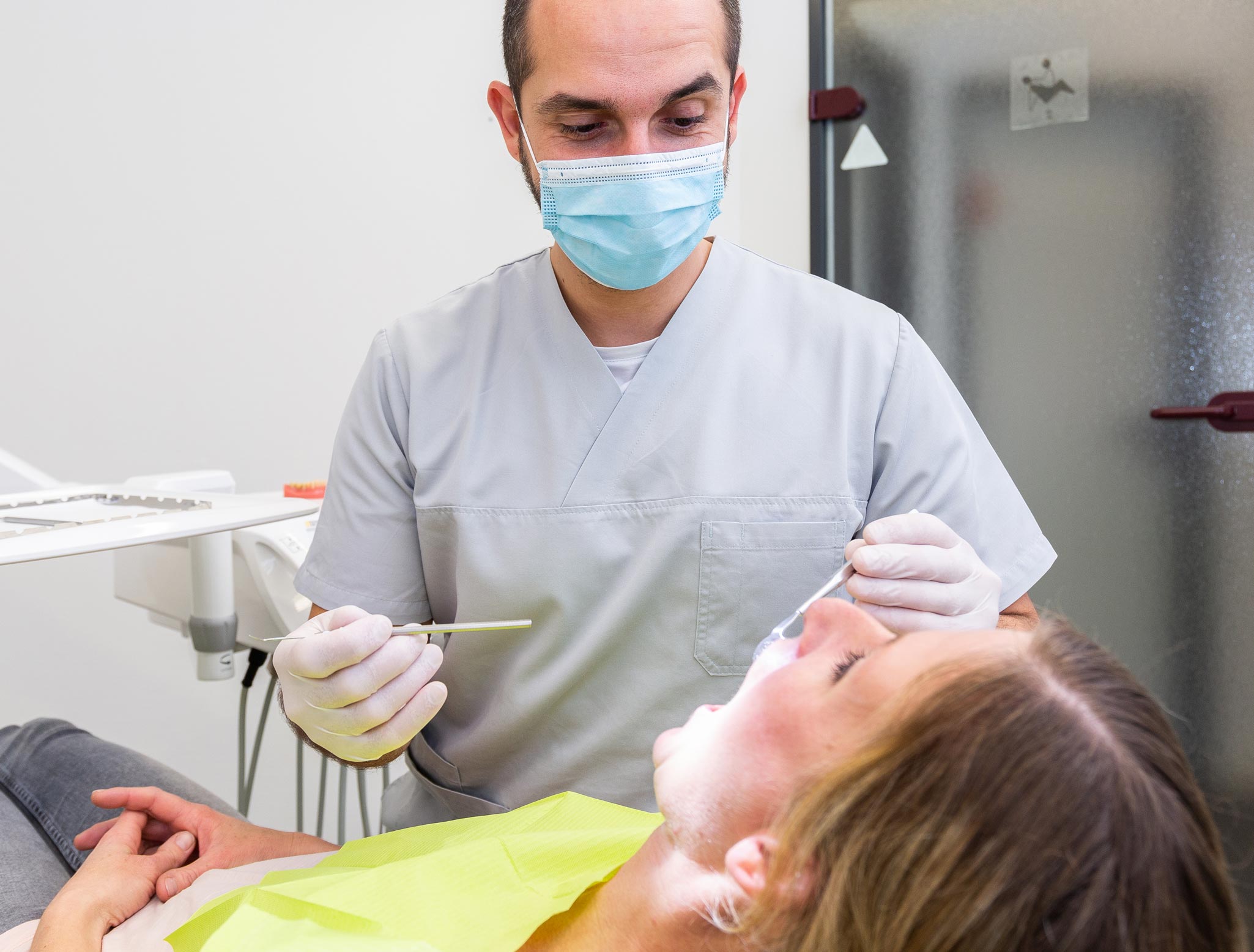 Foto vom Zahnarzt Herr Totolici bei der Untersuchung einer Patientin